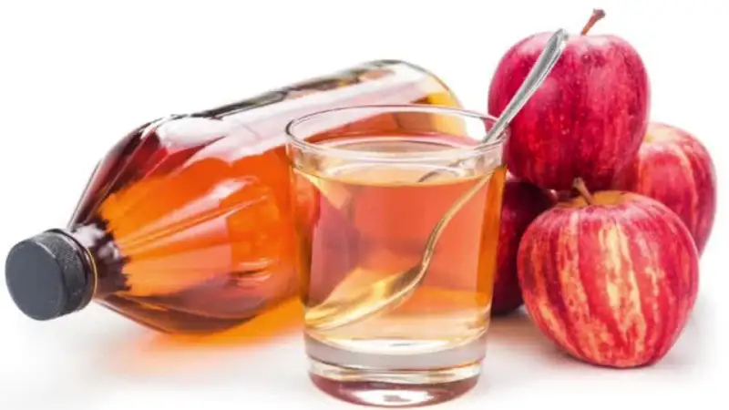Apple cider vinegar with red apples.