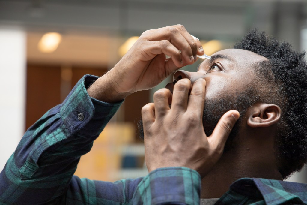 Man administering eye drops