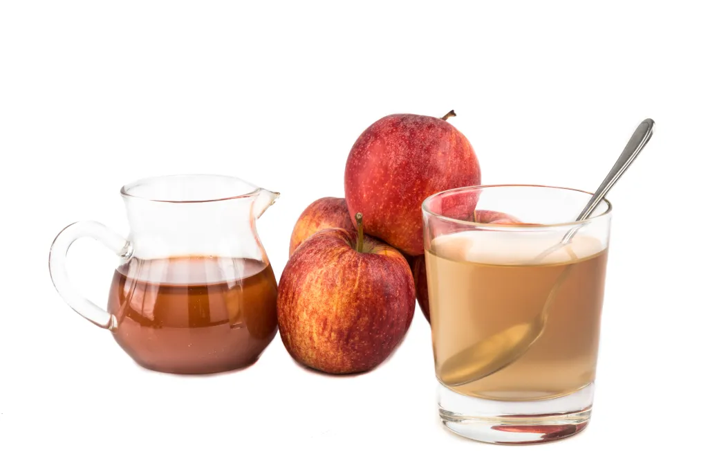 Gass of apple juice next to apples