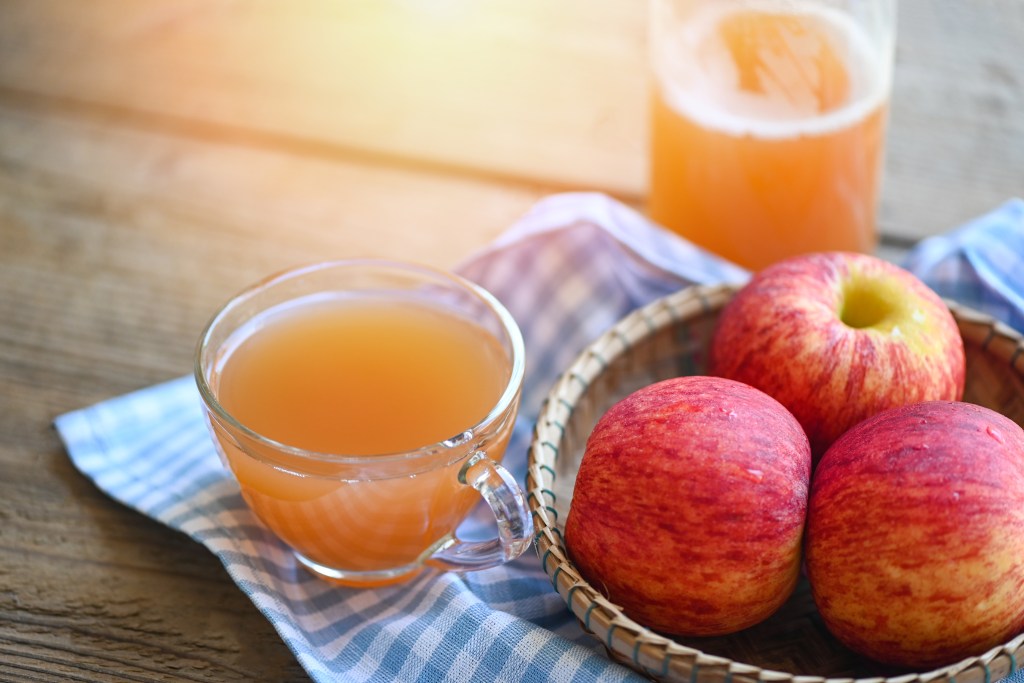 Bowl of apples and a glass of apple cider vinegar