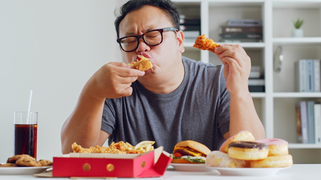 Man eating unhealthy foods&nbsp;