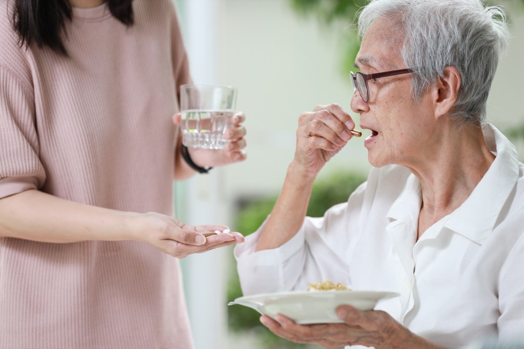 woman taking pill before meal