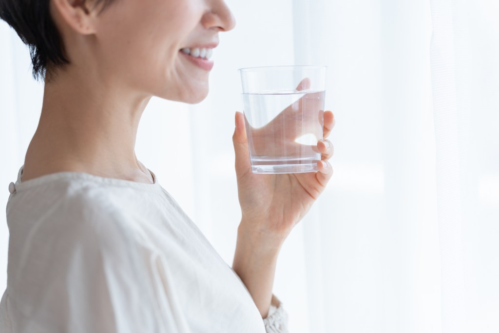 Woman holding glass of water