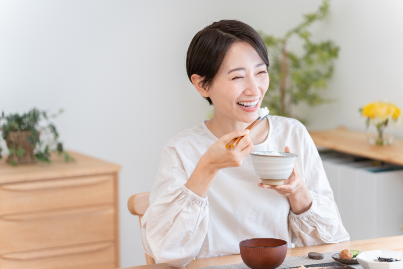 Happy woman eating rice