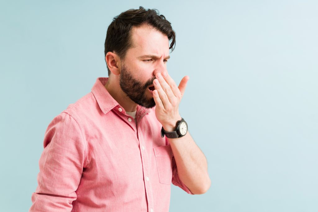 Man smelling his breath