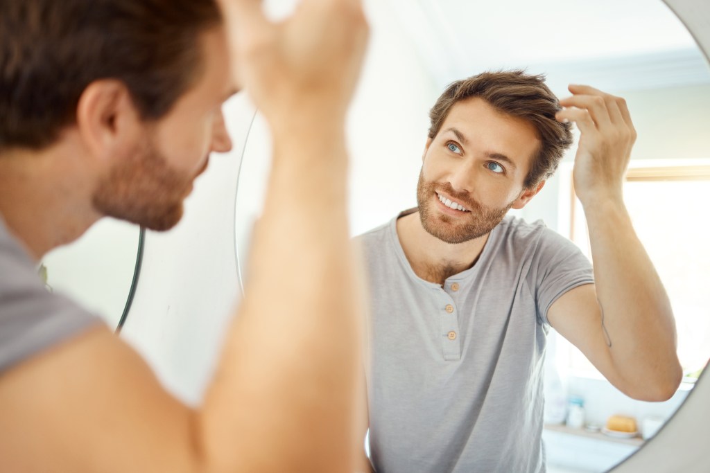 Happy man looking at hair