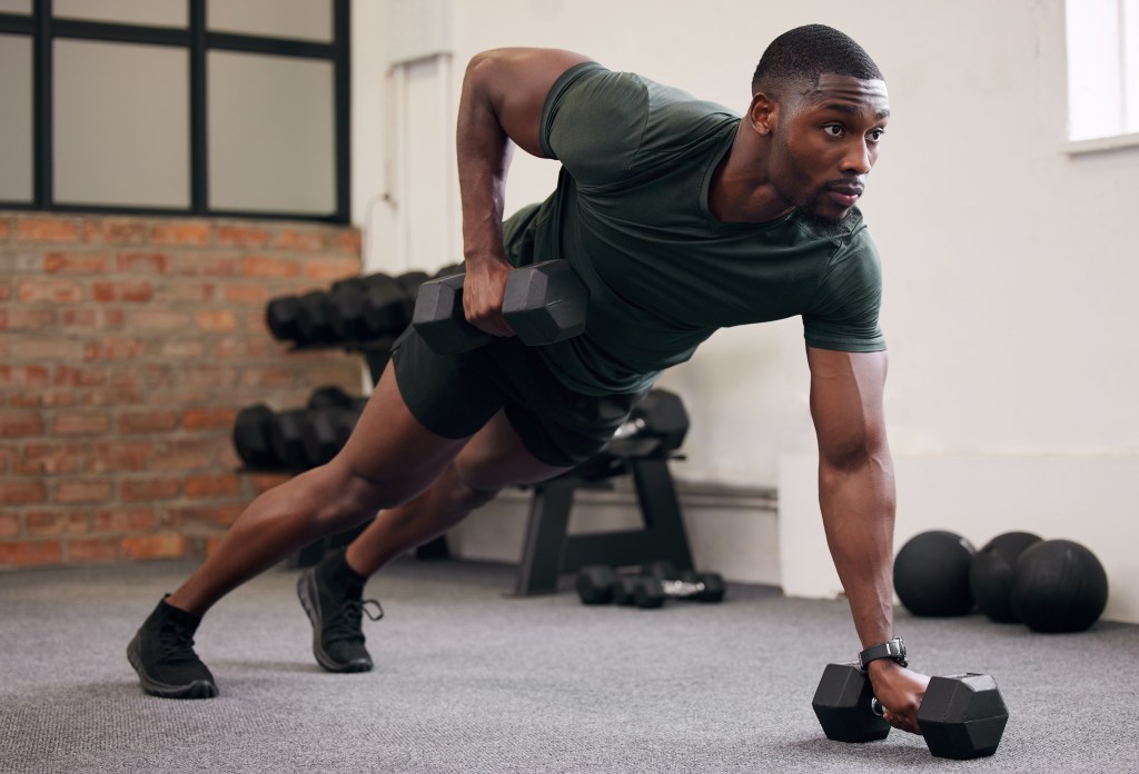 Young fit man lifting weights