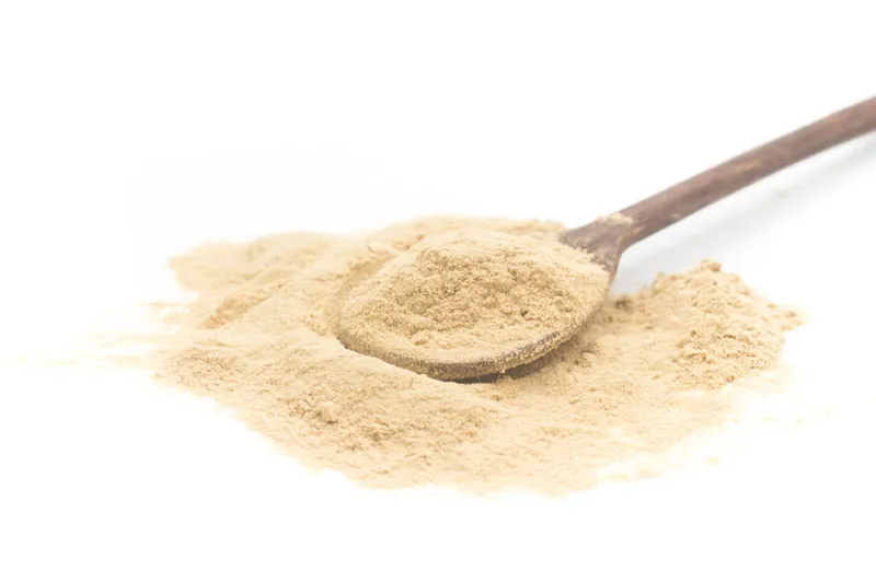 Spoon with maca powder supplement.