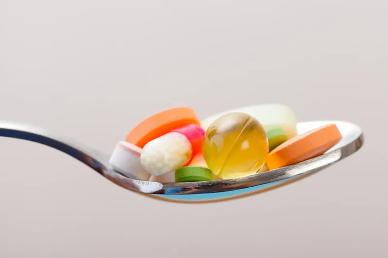 A spoonful of assorted vitamins and supplements of various shapes and colors | Best Time to Take Vitamins