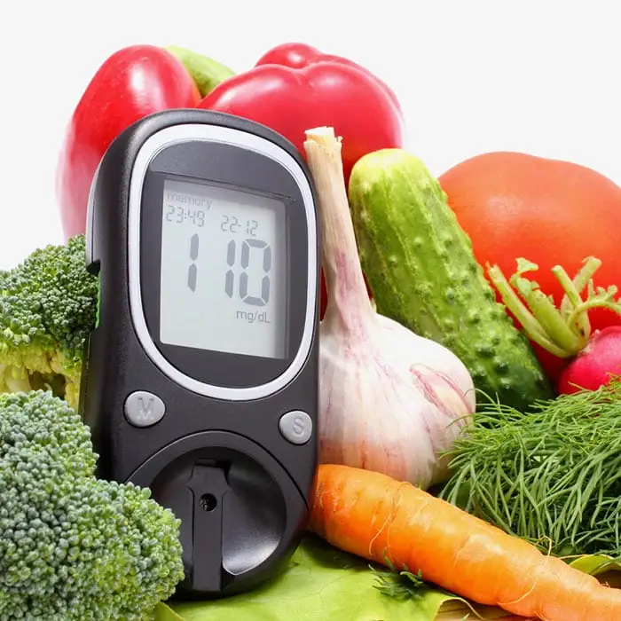 Blood sugar monitor and fresh healthy keto vegetables for a healthy diabetes diet
