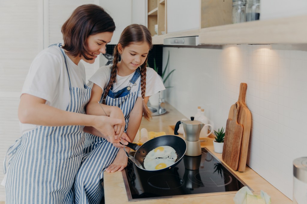Mother and daughter preparing breakfast