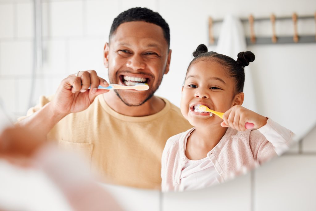 Father and daughter brushing teeth  