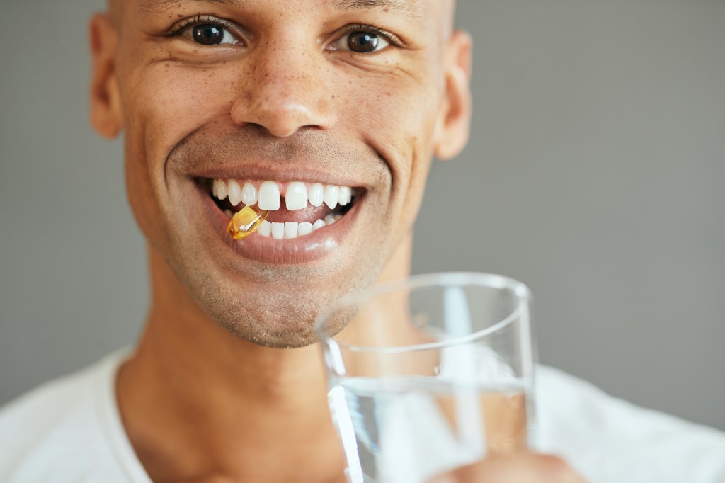 Man biting on a fish oil capsule&nbsp;&nbsp;