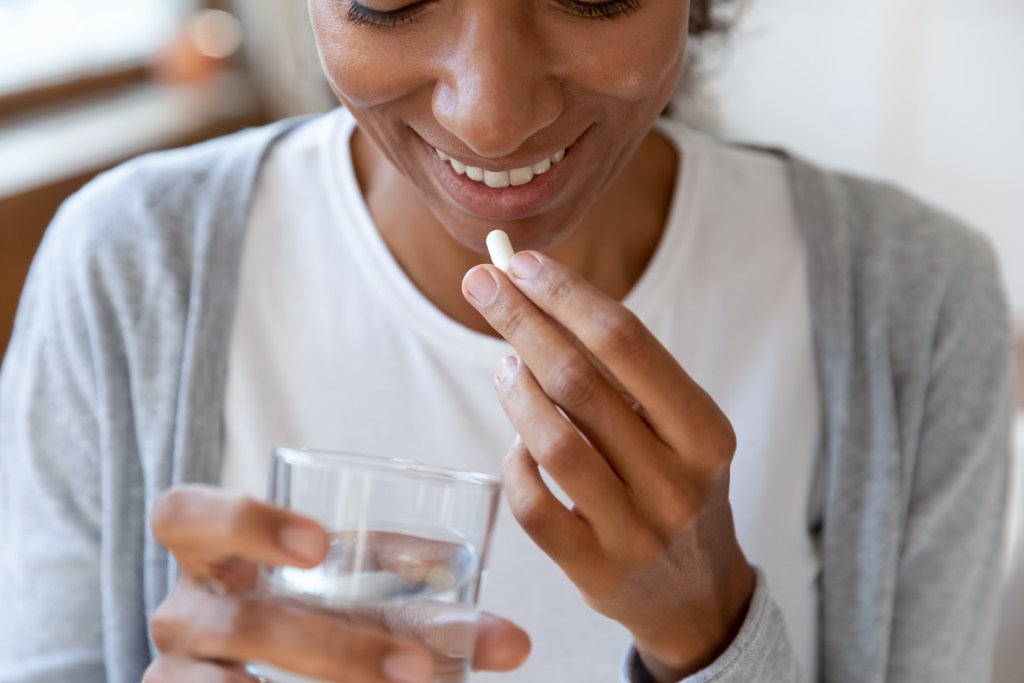 Young woman taking a supplement