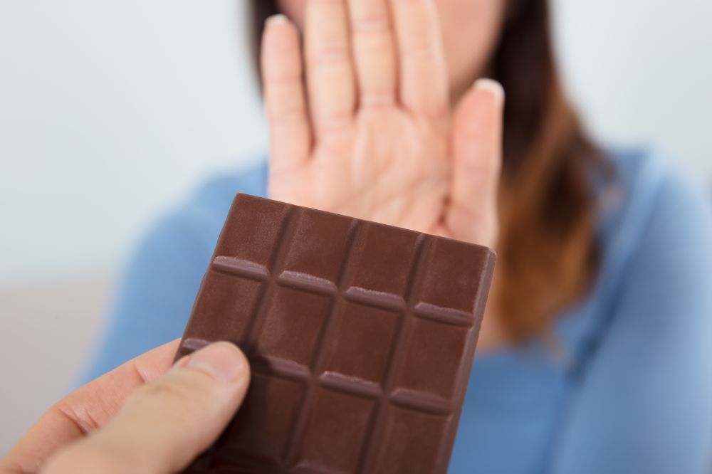 Woman rejecting a chocolate bar and Does Chocolate Have Caffeine?