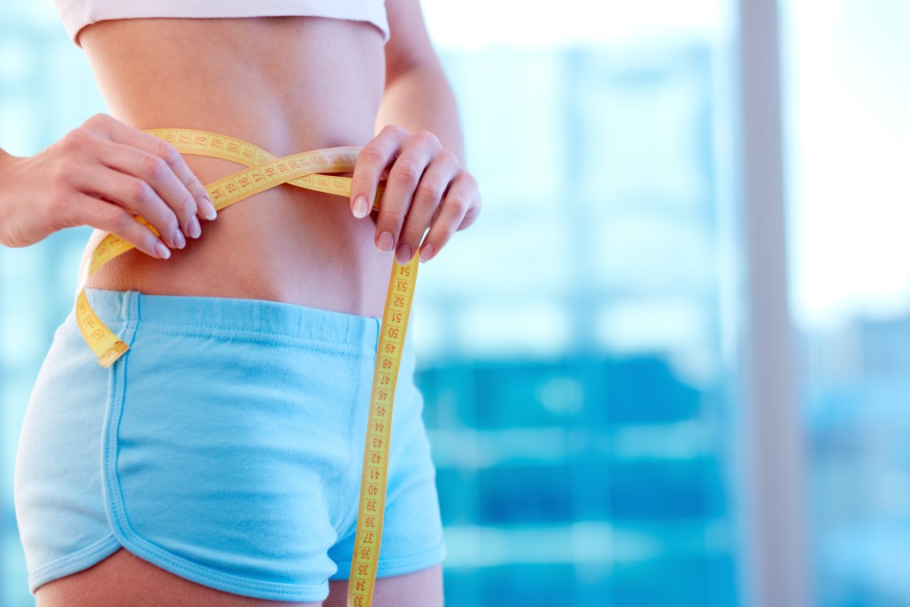 Woman measuring waist circumference
