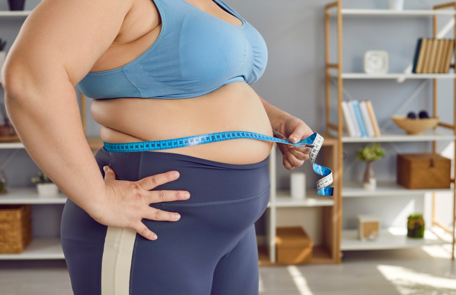 Overweight woman measuring her stomach