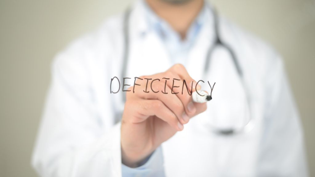 doctor writing the word deficiency
