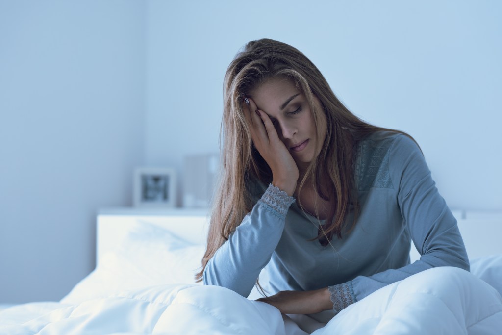 Depressed woman sitting in bed 