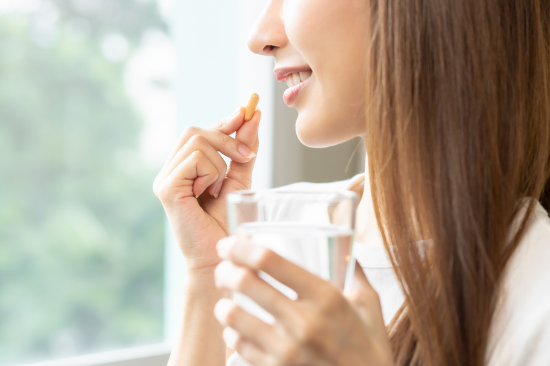 Young woman taking a supplement