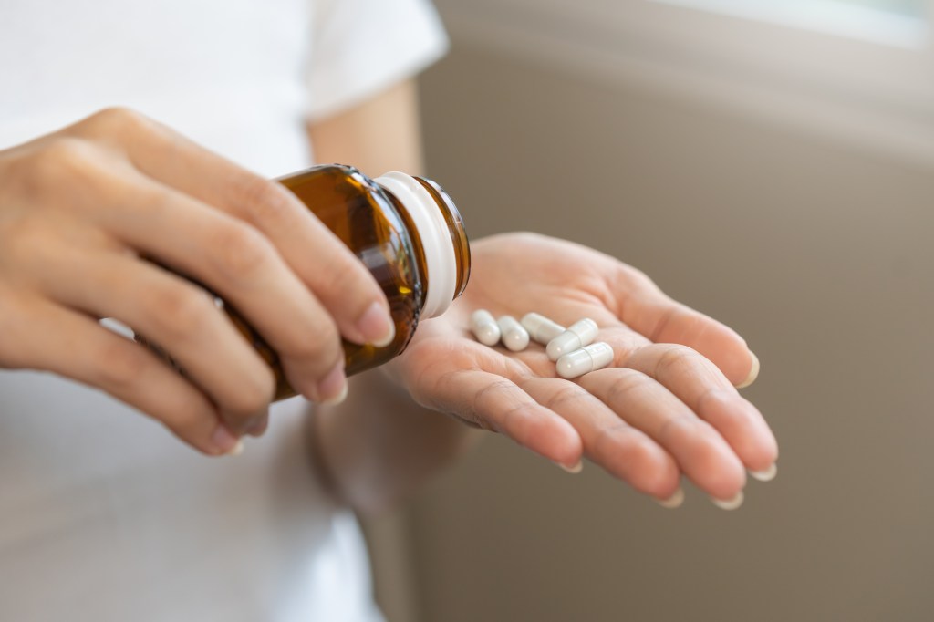 Woman taking dietary supplement