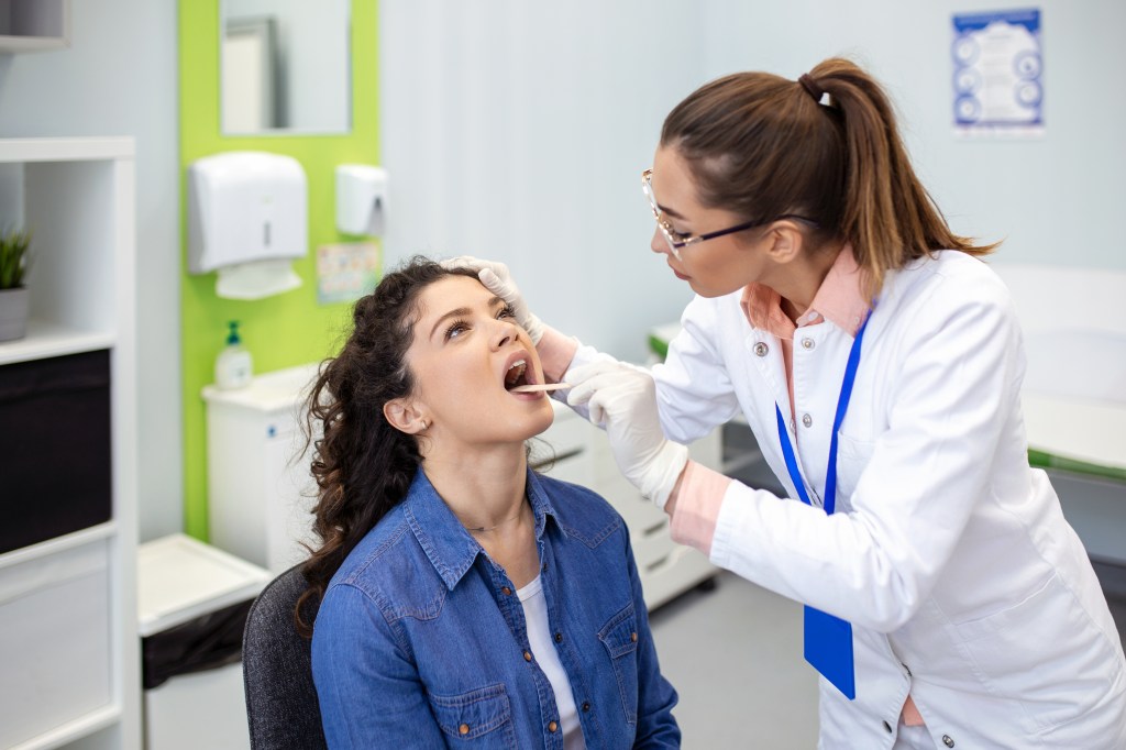 Doctor inspecting sore throat