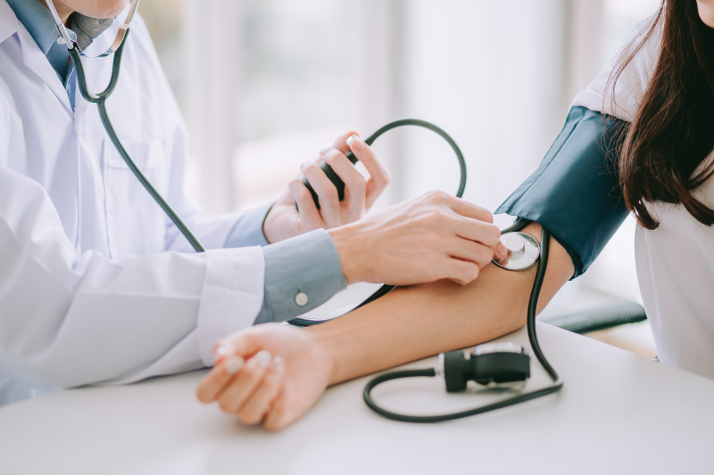 Doctor checking patients blood pressure