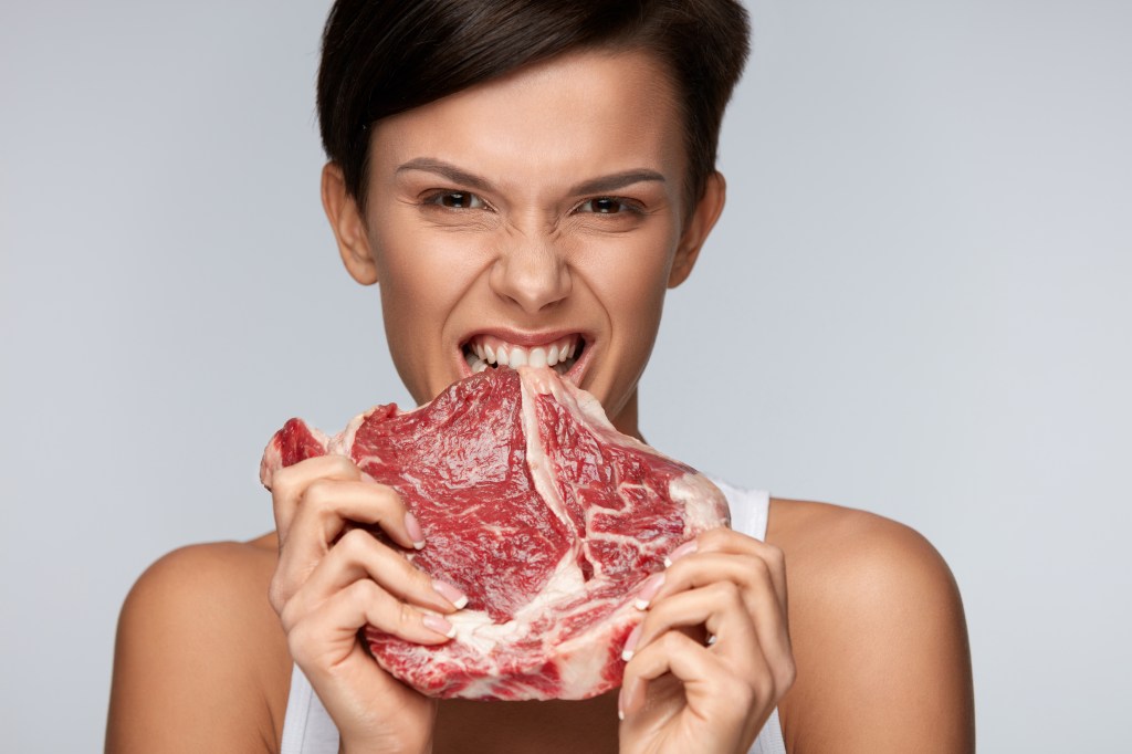 Woman biting into a steak
