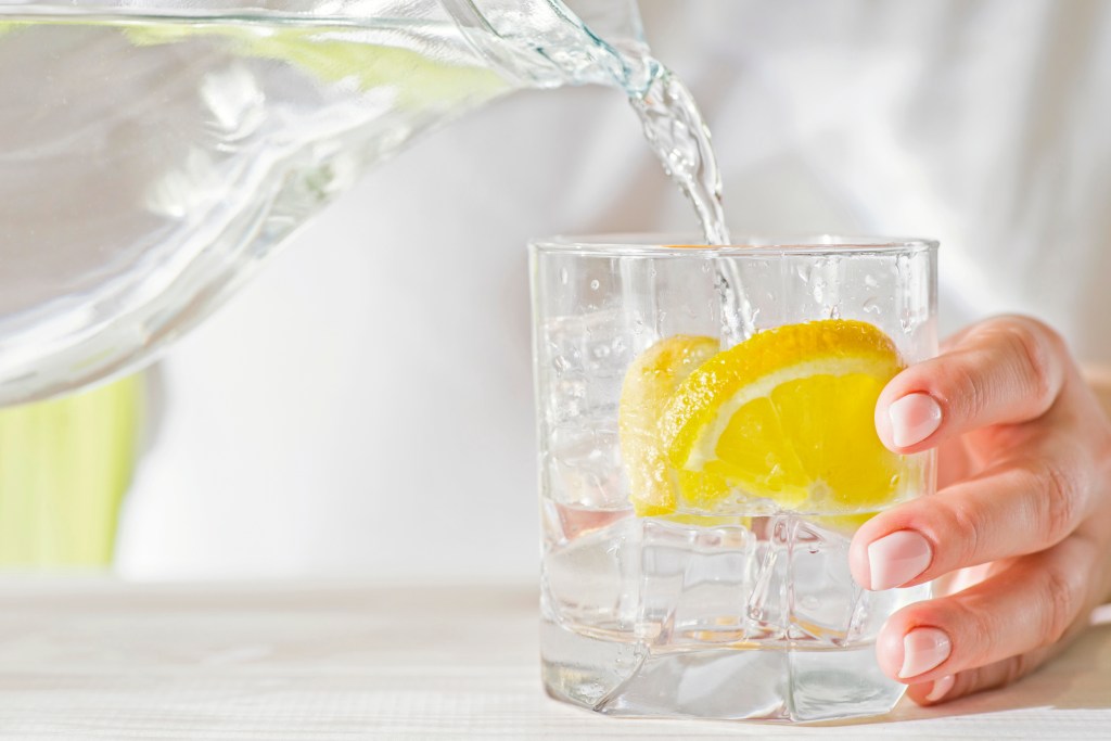 Pouring a glass of lemon water