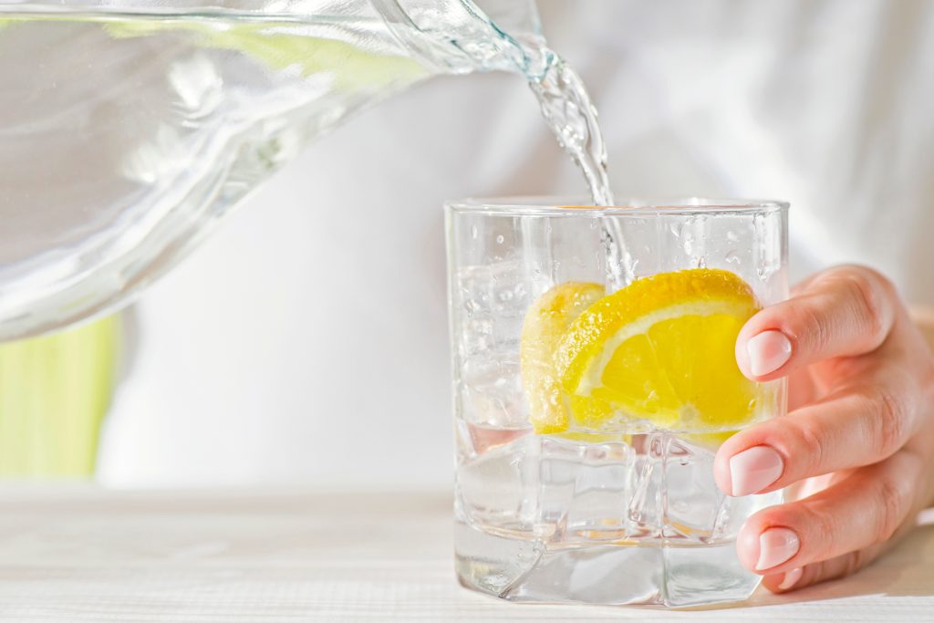 Pouring a glass of lemon water