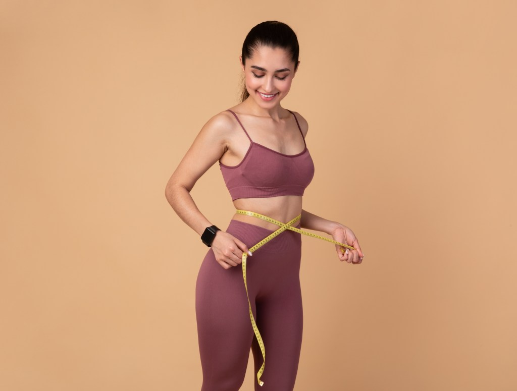 woman measuring her waist