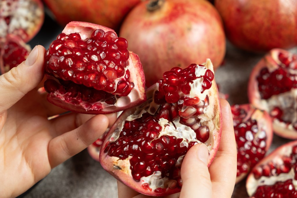 Hand opening pomegranate