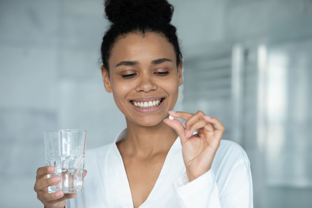 Woman holding pill the Benefits of Oral Probiotics