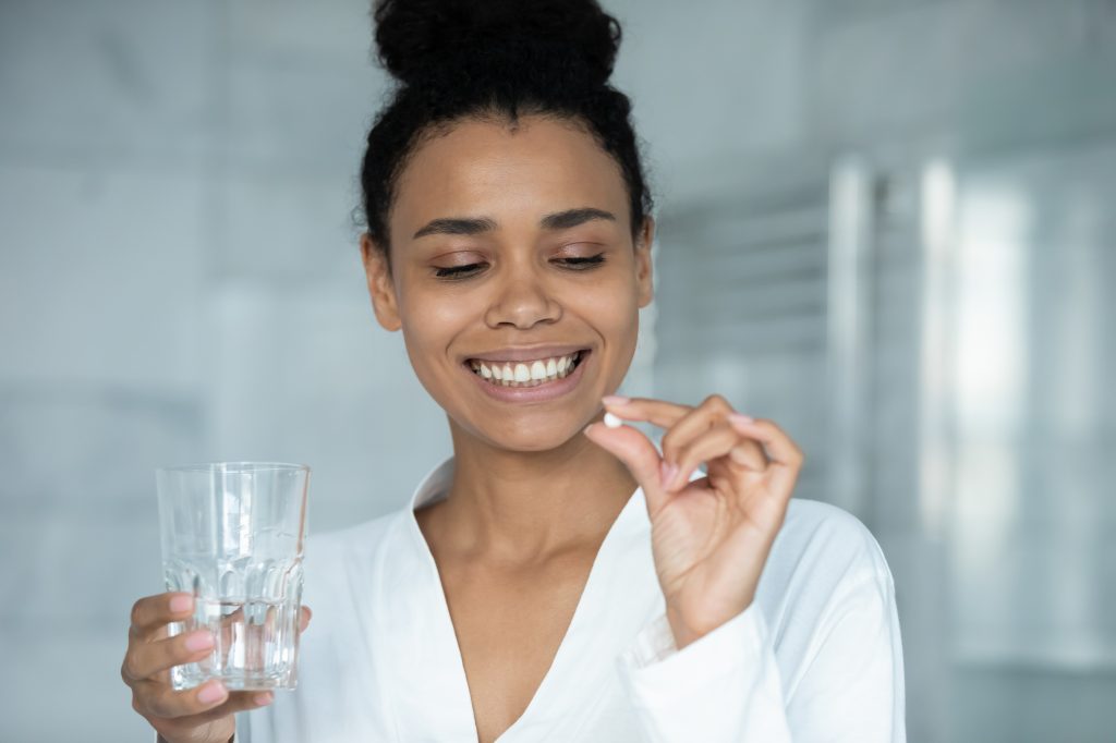 Woman holding pill the Benefits of Oral Probiotics