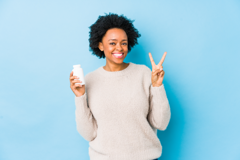 Woman holding supplement container