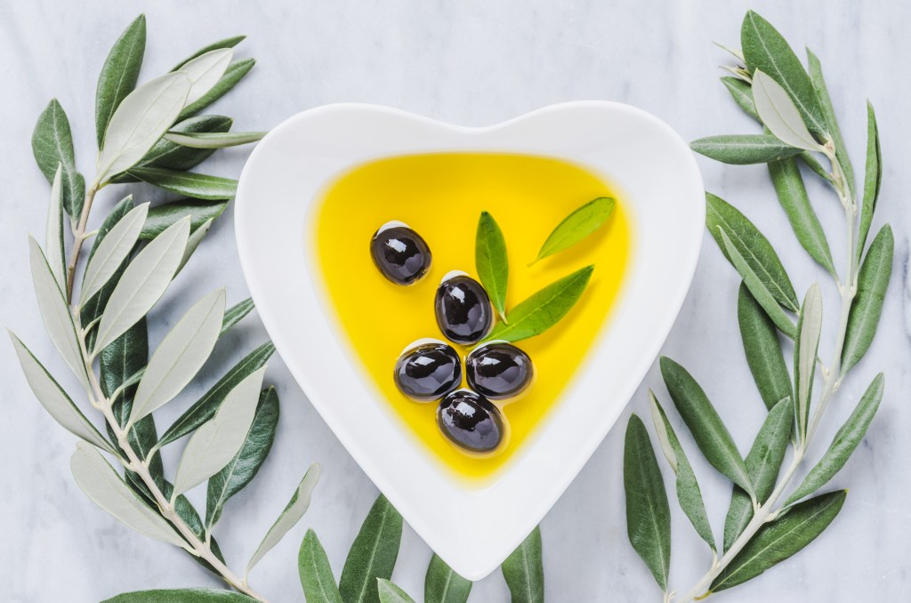 Olive oil and olives in heart plate