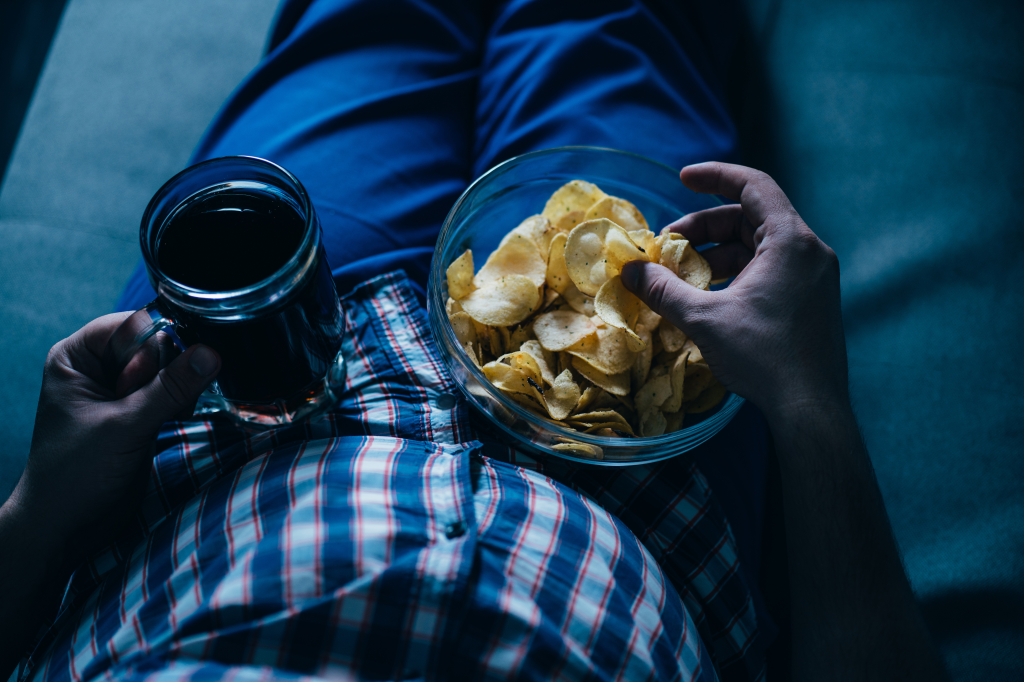 Man holding beer and snacks