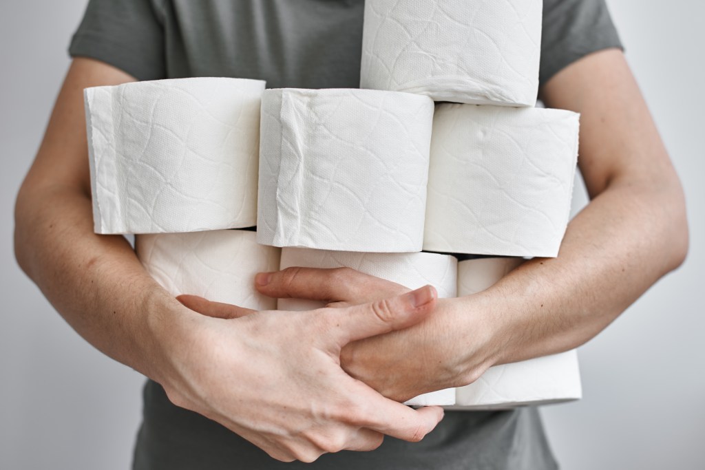 Man holding extra toilet paper