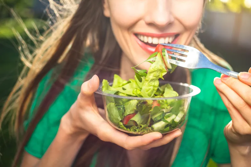 Woman eating a green salad