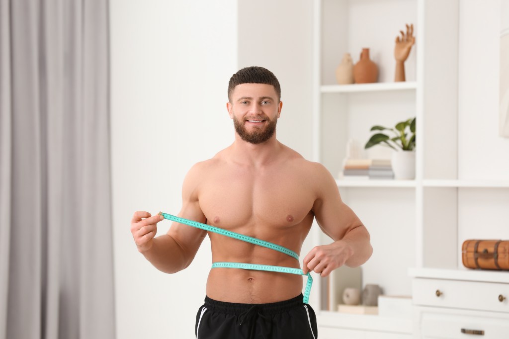 Athletic man measuring his belly