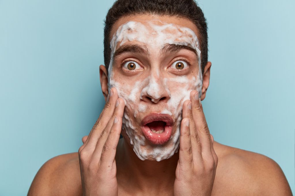 Young man washing his face  