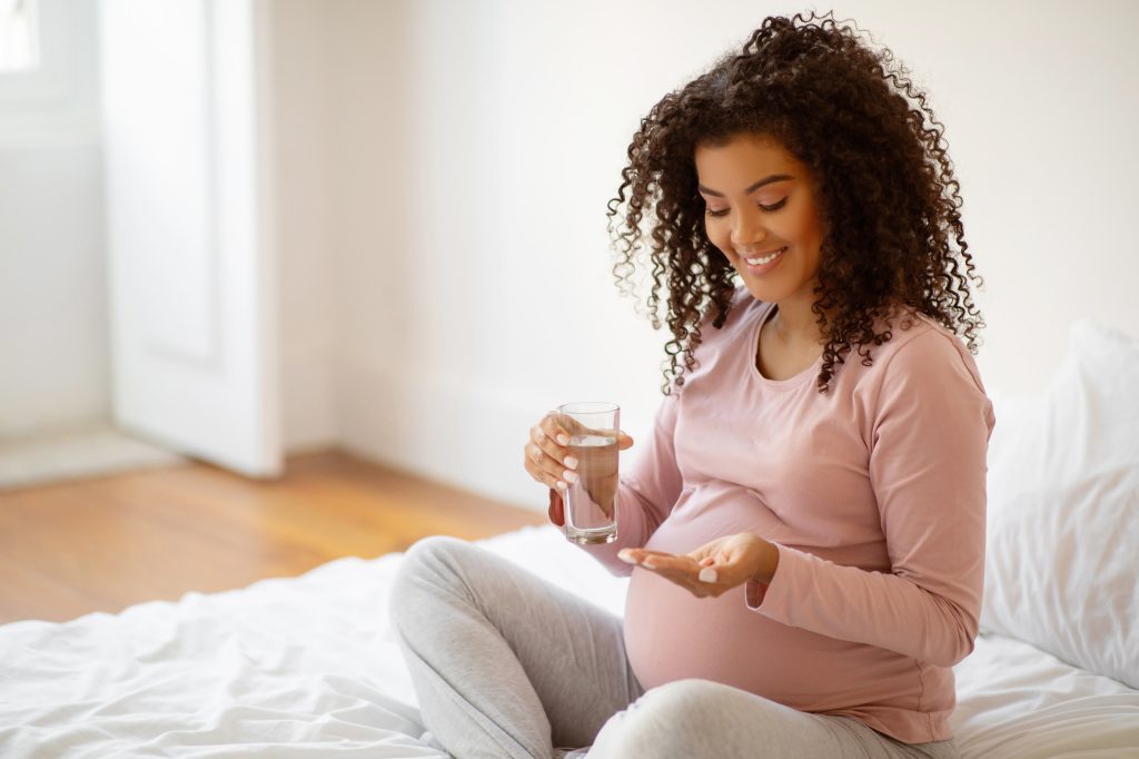 Pregnant woman taking a supplement  