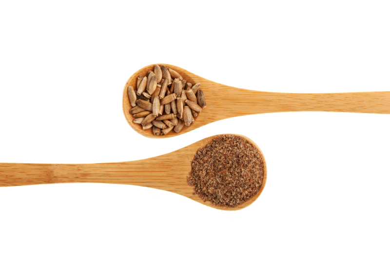 Ground milk thistle seeds on a wooden spoon