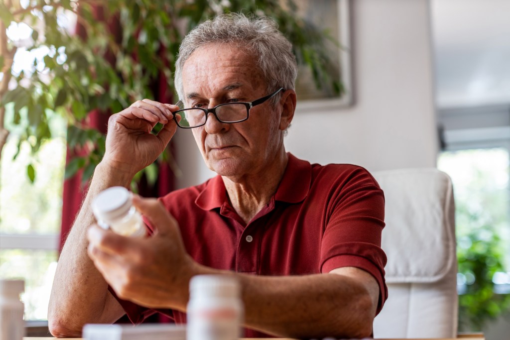 Senior man reading supplement label
