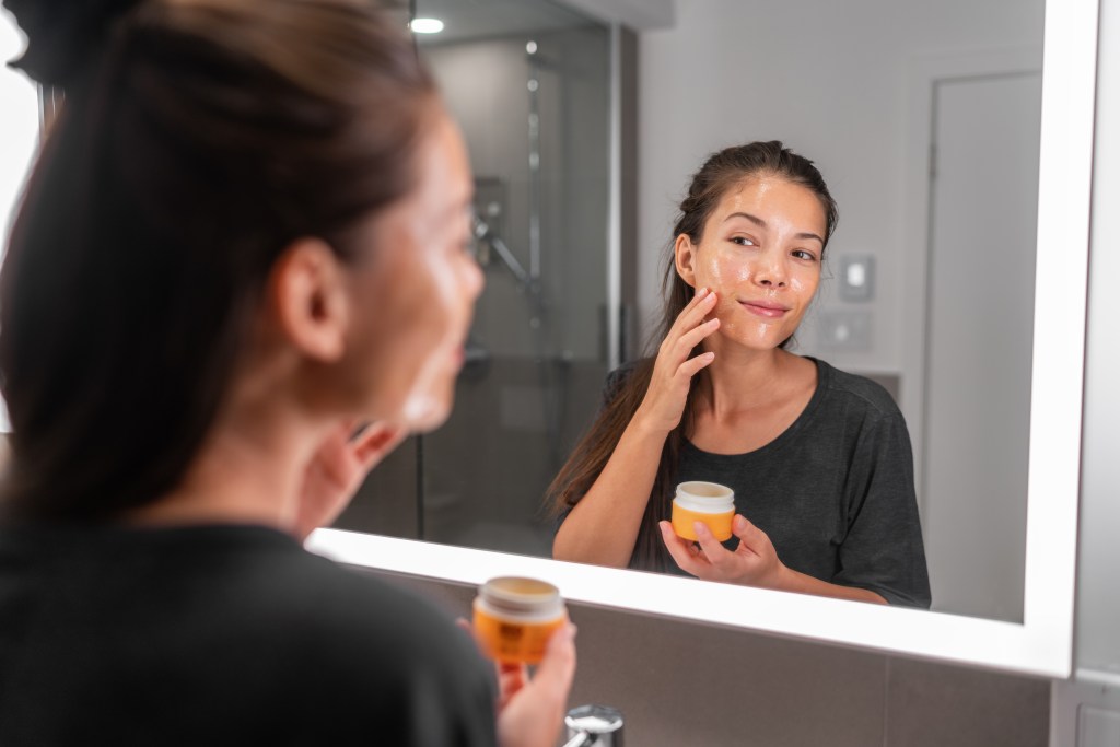 Woman applying skin care product