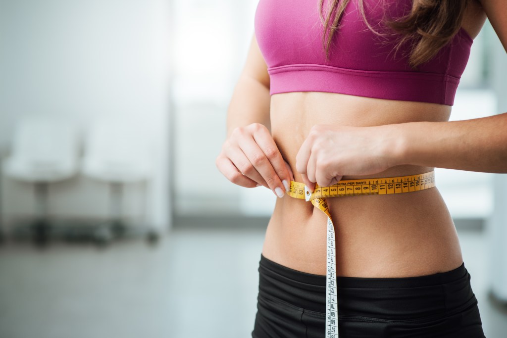Woman measuring her waist