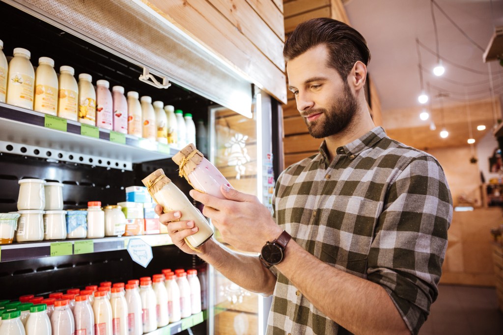 Man comparing yogurts