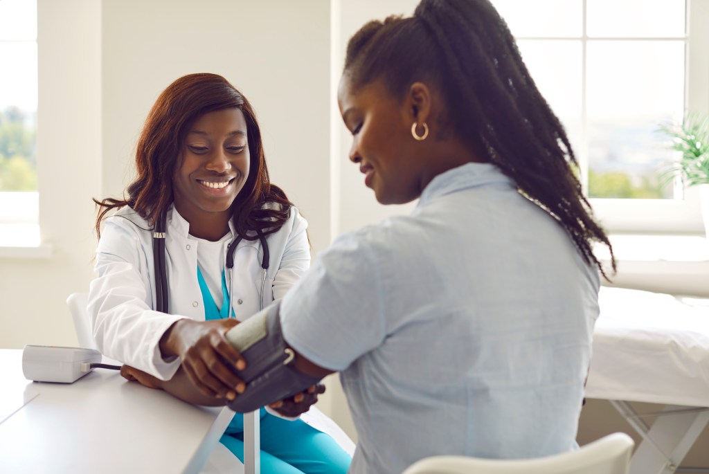 Doctor checking women's blood pressure