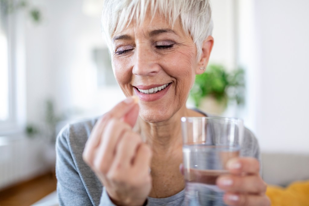 Older woman taking a supplement