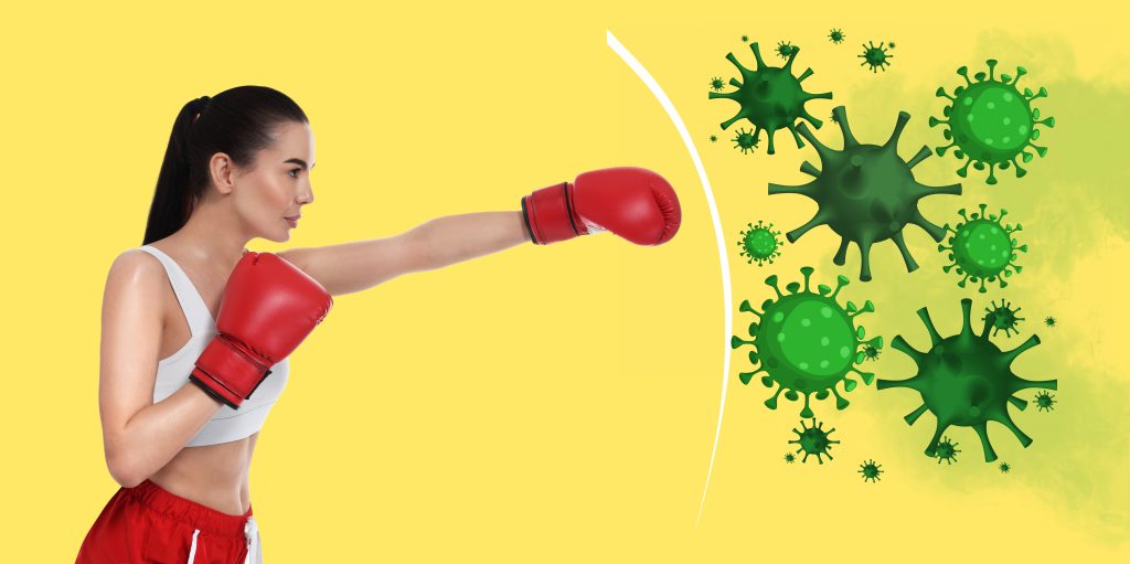 Woman wearing boxing gloves and punching a virus